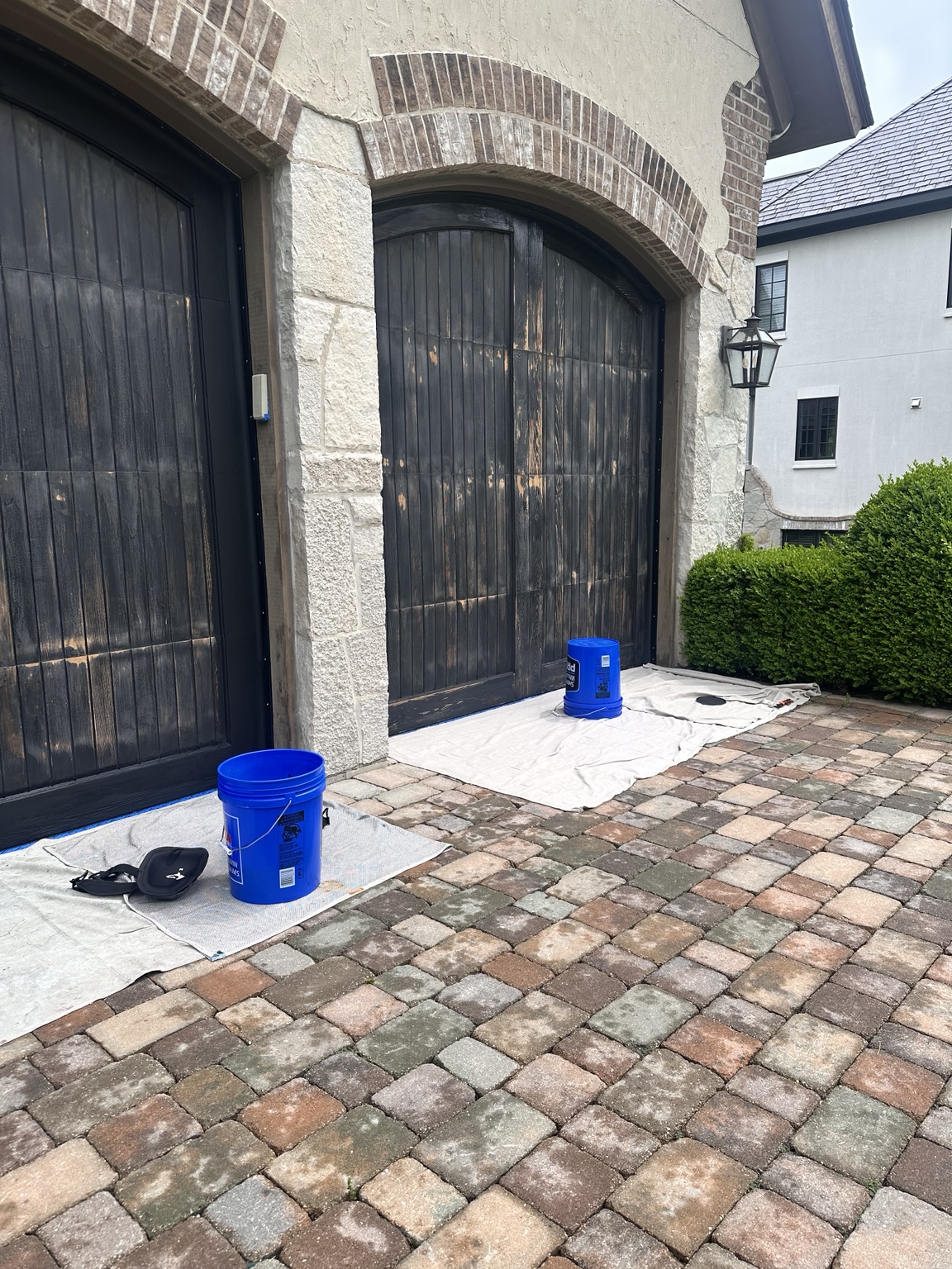 Garage doors during surface preparation with drop cloths in place